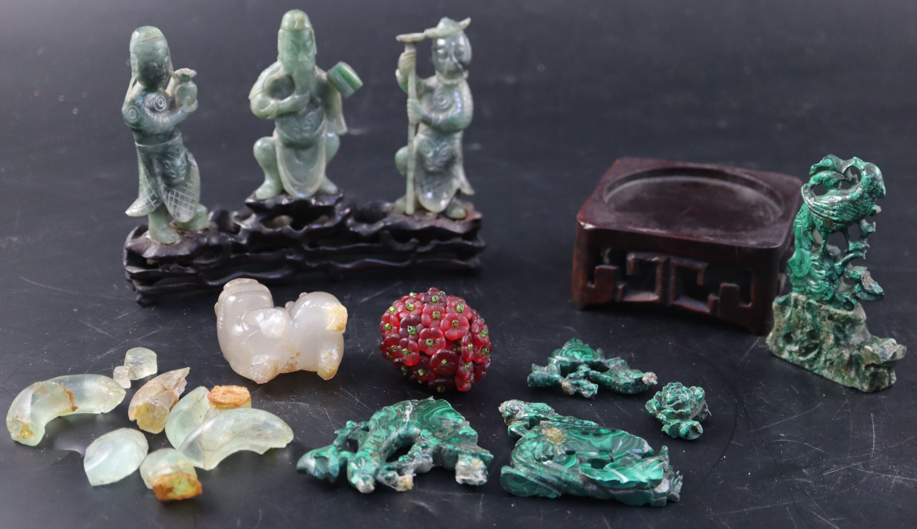 A set of three Chinese carved hardstone figures of immortals, stand; shi shi, malachite fragments etc.